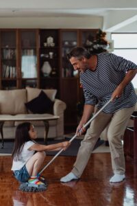 A father and daughter cleaning the house