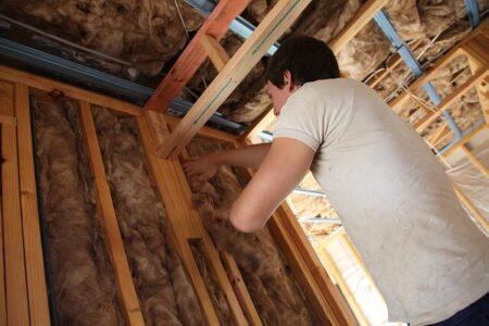 homeowner checking home insulation to prepare house for winter.